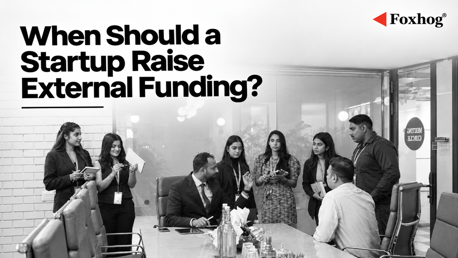 Group of professionals in a conference room with a bold headline: 'When Should a Startup Raise External Funding?' and Foxhog logo in the corner, implying an article cover about startup funding.